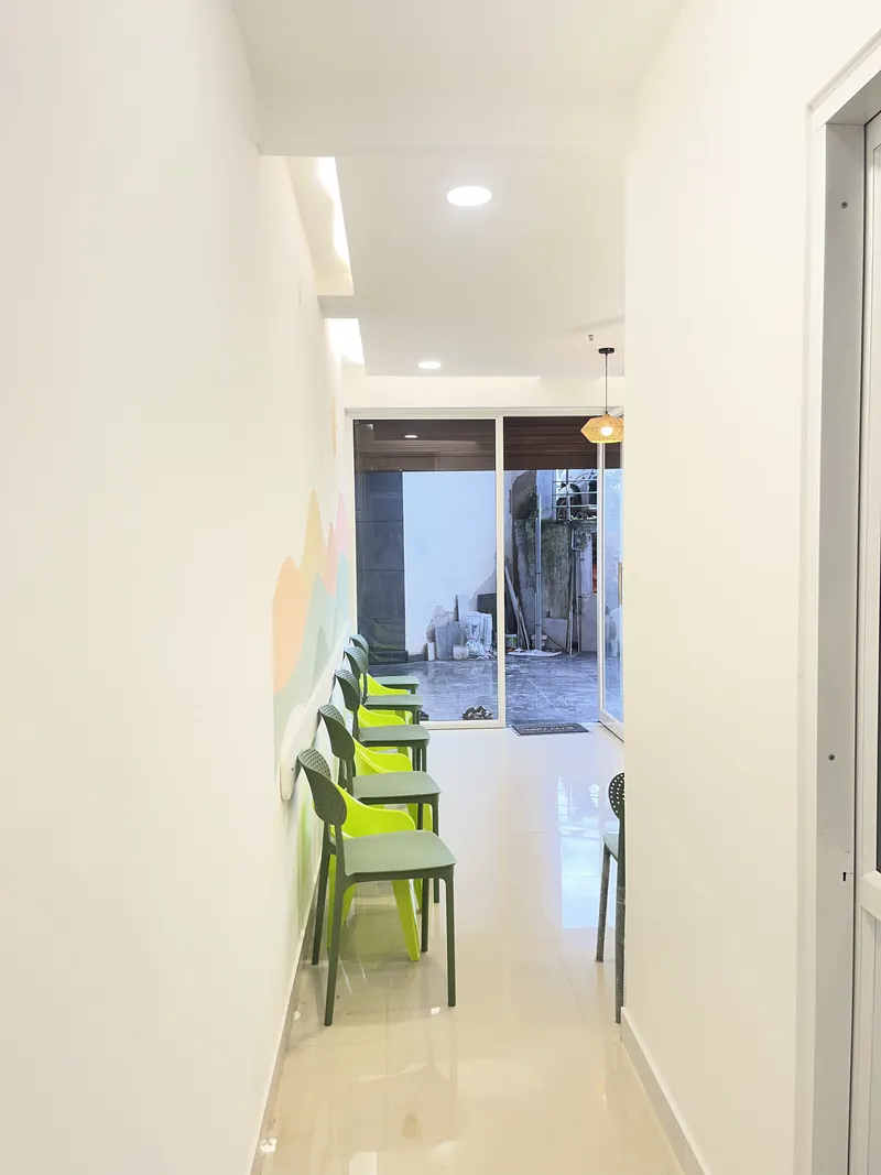 Waiting area with green chairs and a pastel mural